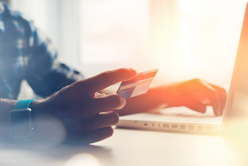 Person putting credit card numbers into laptop